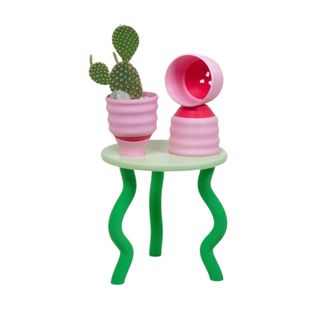 A green and pink plant holder with plant pots on top