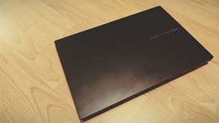 An Early Grey ASUS Vivobook Pro 15 OLED (2024) sitting on a wooden floor