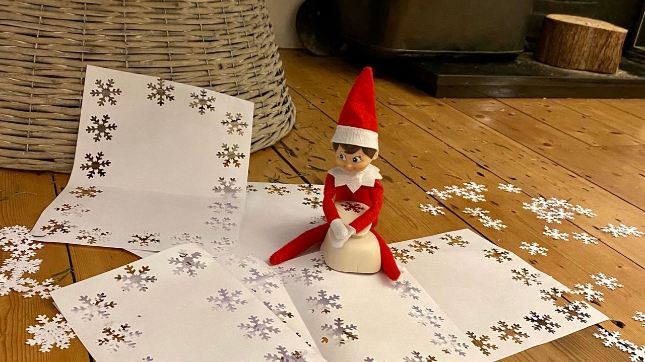 elf on the shelf with hole punched snowflakes