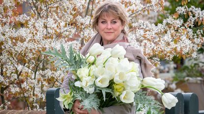 gardens expert Sarah Raven holding a large bunch of white tulips