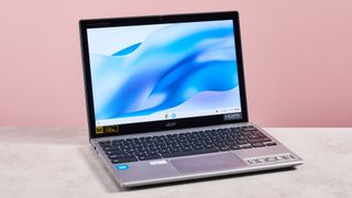 Acer Chromebook Spin 312 open on desk with pink background