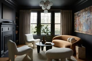 Dark blue-black painted living room with white armchairs, black wood coffee table and orange curved sofa