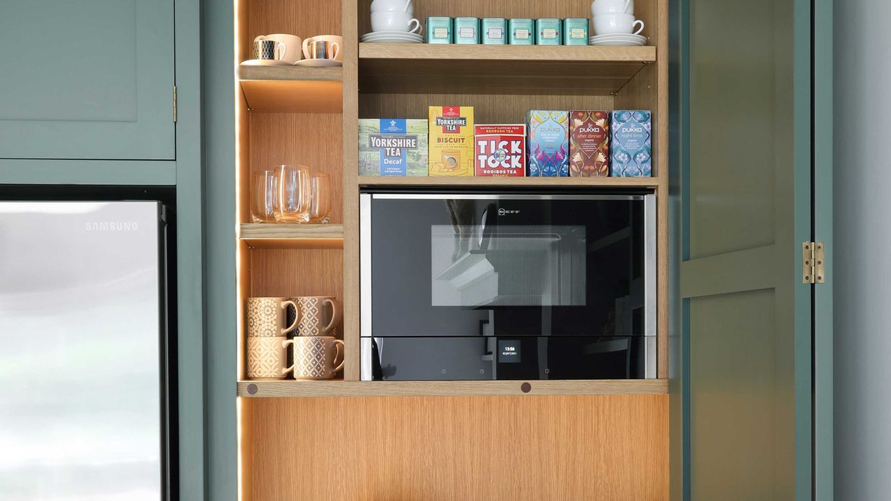 modern microwave in kitchen cupboard with range of teas