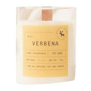 A glass verbena candle with a yellow label