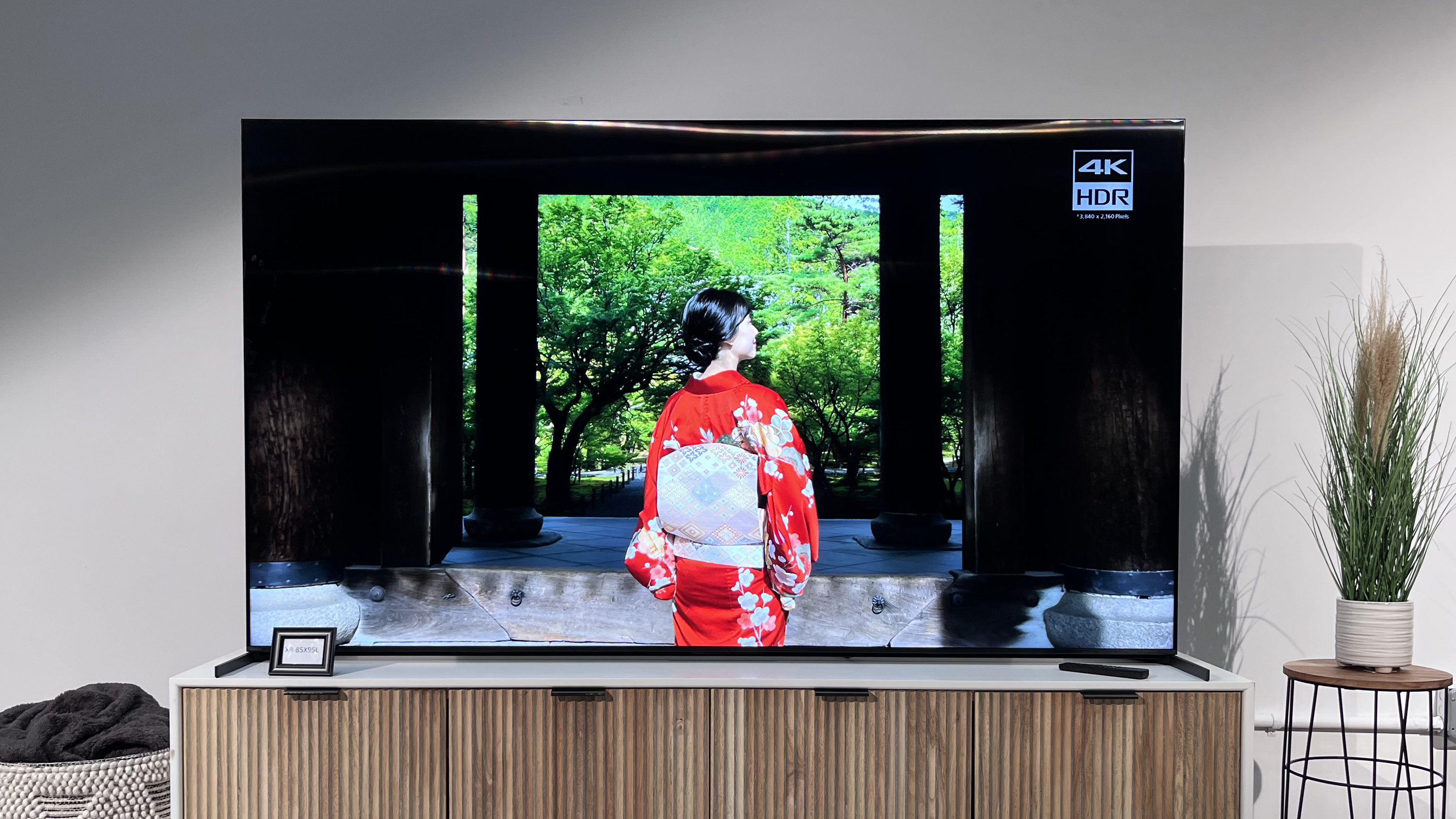 The Sony X95L on a TV stand, with an image showing a Japanese house