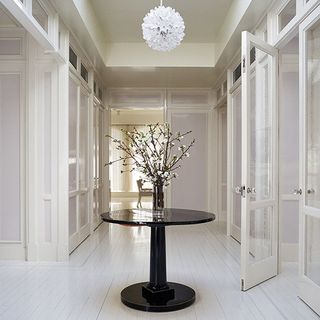 white hallway with black table and glass doors