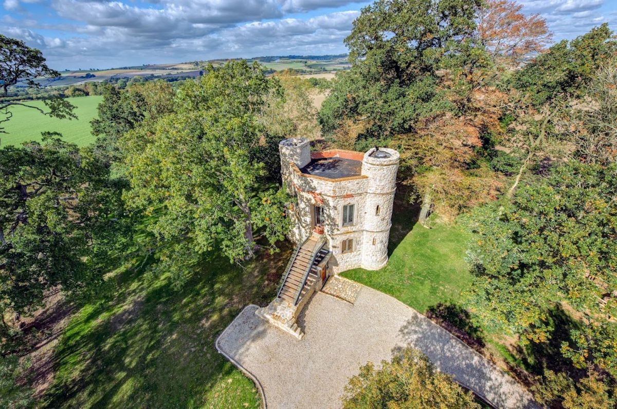 An overhead shot of DInton Castle showing the forestry surrounding and the gravel driveway