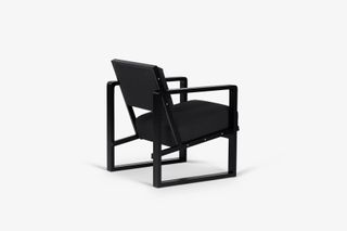Back view of black wooden lounge chair with upholstered seat and back by Erich Dieckmann