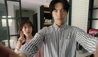 two people (Jung So-min and Lee Min-ki) take a selfie while standing in an apartment, in Netflix k-drama 'Because This Is My First Life'