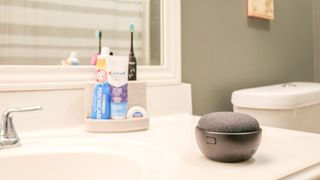 A Google Home Mini with a battery base in a bathroom