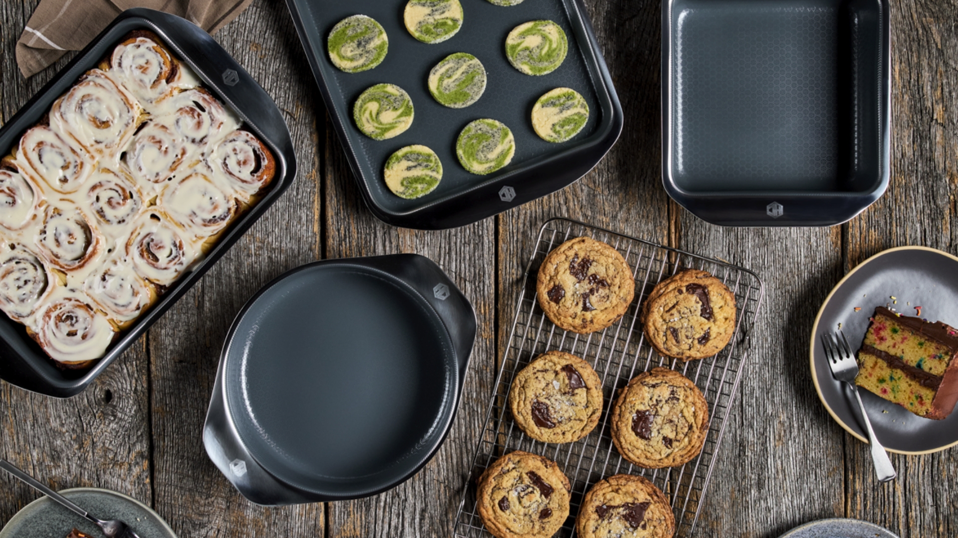 HexClad Hybrid Bakeware being shown with bakes inside, cookies, pies, cake, and cinnamon rolls