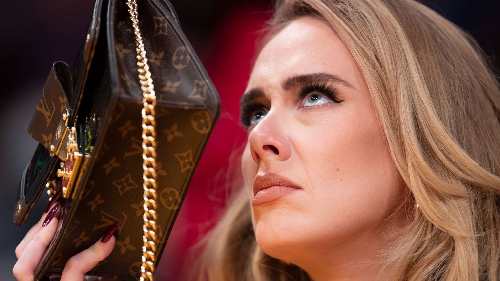 los angeles, ca october 19 singer adele uses her purse to hide from the tv camera while she sings along to her song being played to the audience while attending a game between the golden state warriors and the los angeles lakers on october 19, 2021 at staples center in los angeles allen j schaben los angeles times via getty images