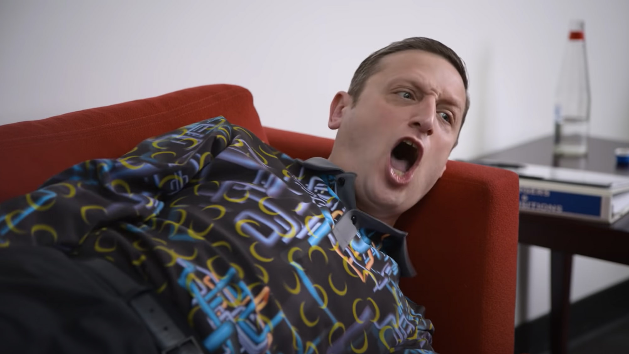 Tim Robinson shouts while lying on a couch in I Think You Should Leave