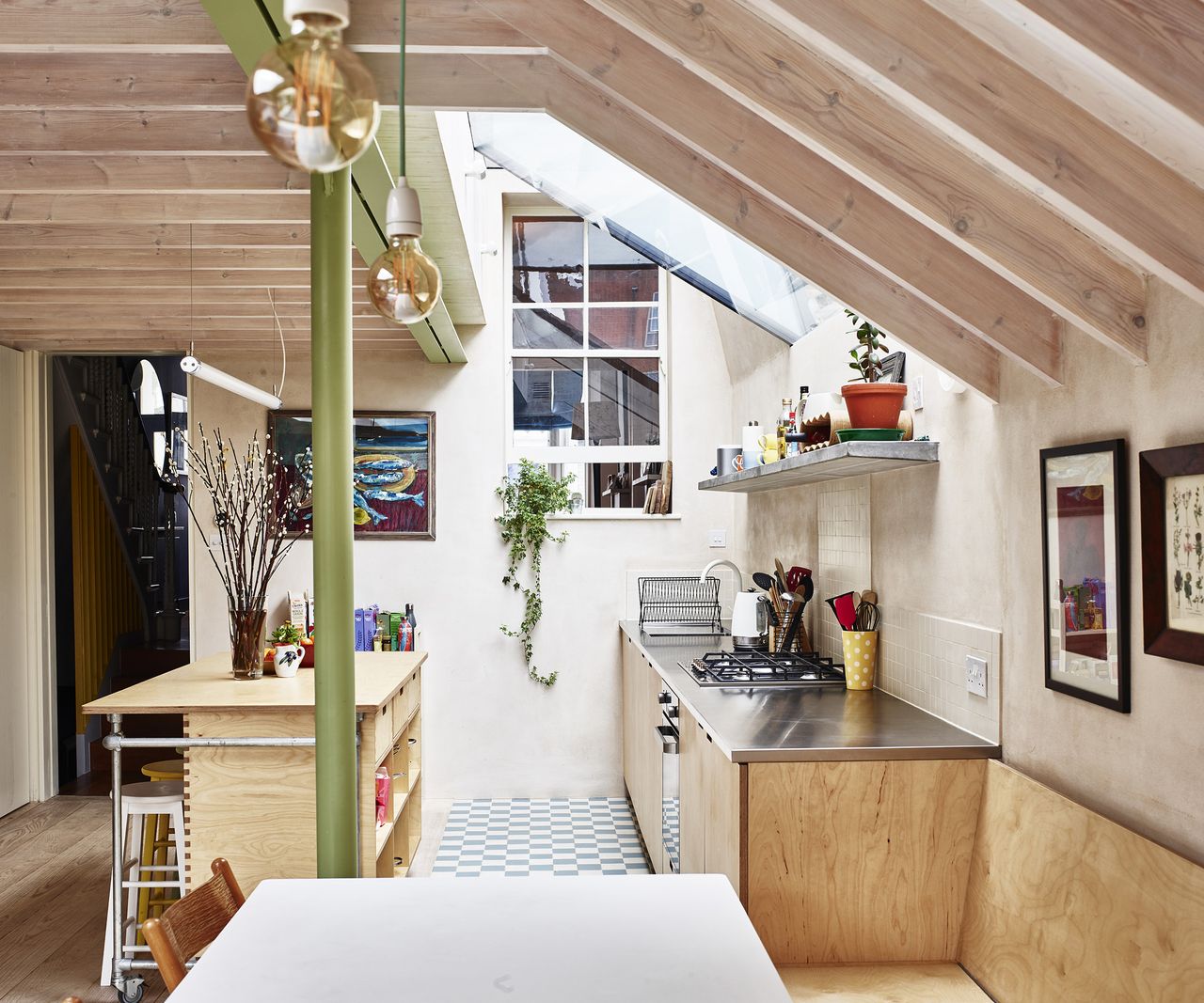 A kitchen extension built using natural materials with a pitched roof and lots of natural light