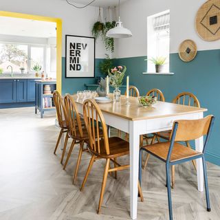 kitchen diner with blue and white half painted wall and wooden dining table and chairs