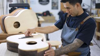 Man working on a guitar in his workshop