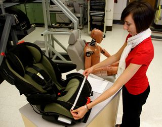 Julie Bing, a researcher with the Ohio State University College of Medicine, measures the dimensions of a child's car seat. She and her colleagues measured and analyzed nearly 3,200 car and car-seat combinations. They found that not all car seats fit into all cars the correct way.