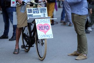 A cyclist displays a sign in support of Jurgen Conings