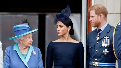 Queen Elizabeth II, Meghan, Duchess of Sussex and Prince Harry, Duke of Sussex watch a flypast to mark the centenary of the Royal Air Force from the balcony of Buckingham Palace on July 10, 2018 in London, England