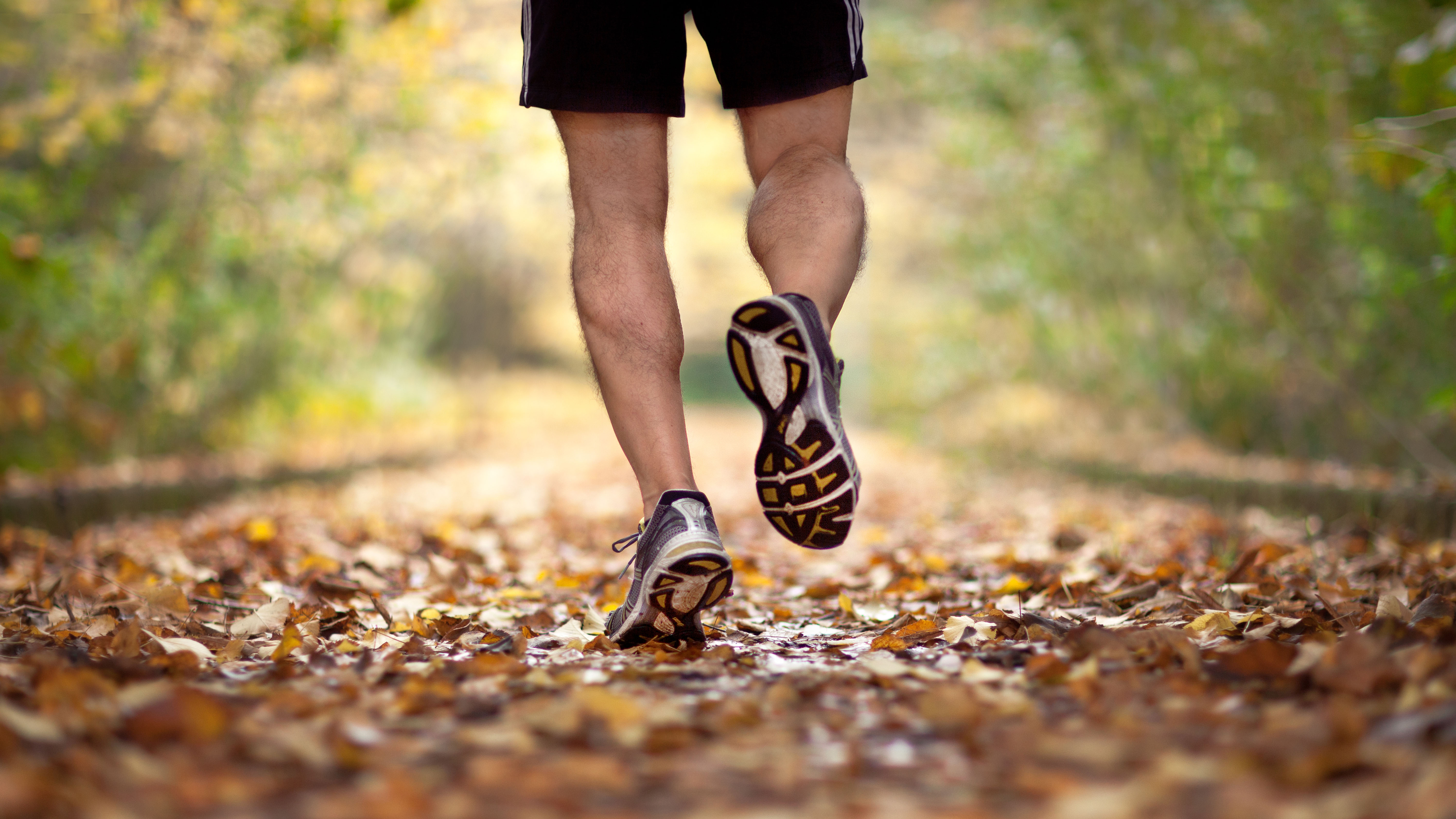 Man running on fallen leaves in fall