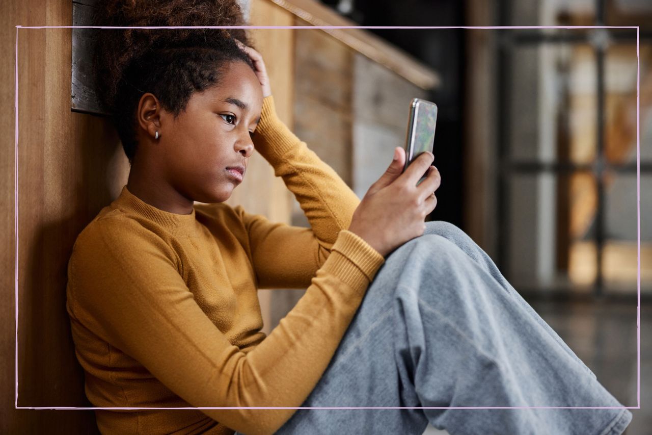 Young girl looking worried while watching her phone