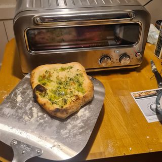 Cooked garlic bread next to the Sage Smart Oven Pizzaiolo