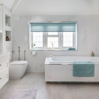 white tiled bathroom with white flooring and bathtub
