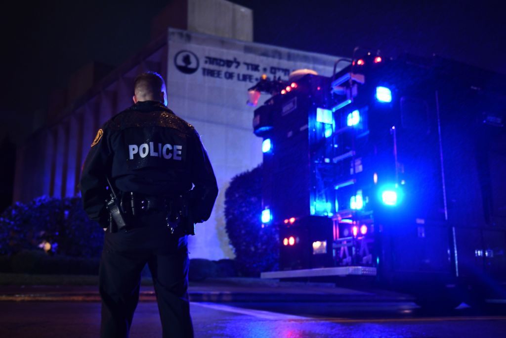 A police officer stands under the rain outside the Tree of Life Synagogue after a shooting there left 11 people dead in the Squirrel Hill neighborhood of Pittsburgh on October 27, 2018.