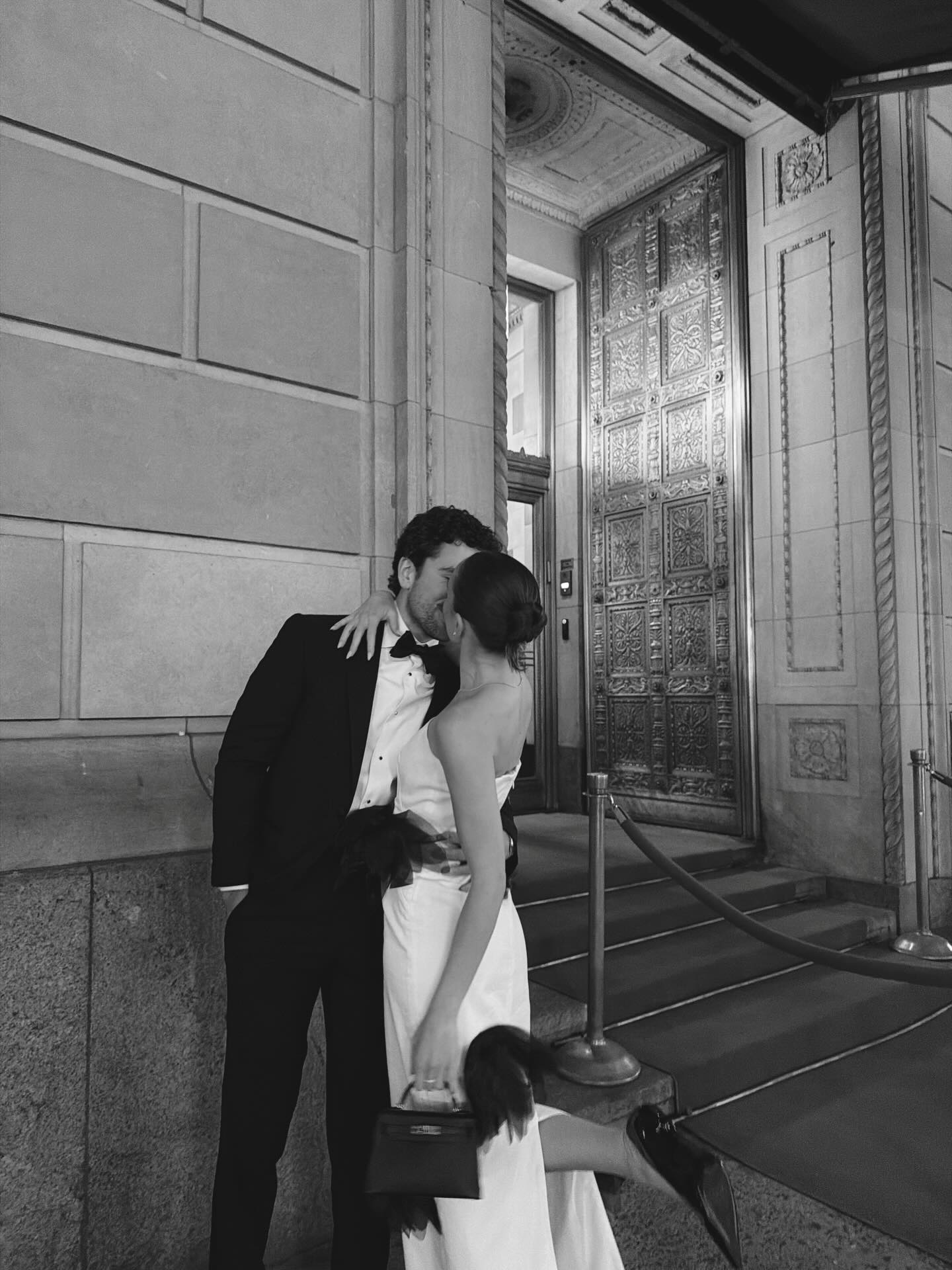 A couple wearing wedding guest outfits.