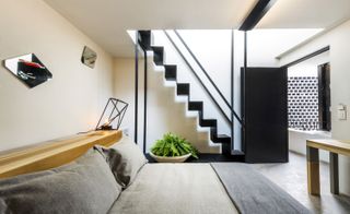 Staircase to upper floor, simple decoration with plant, table and few fixtures