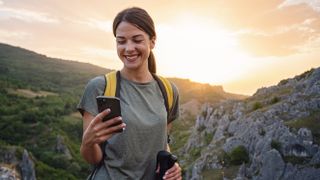 Woman using mobile phone on mountain hike