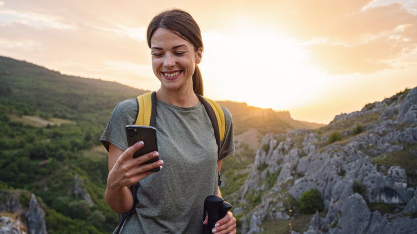 Woman using mobile phone on mountain hike