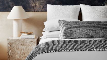 Stiff neck from sleeping - grey and white stacked on neutral bedding in neutral bedroom