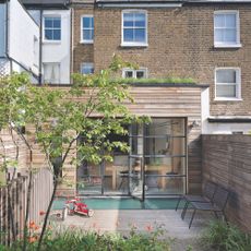 Exterior of a rear kitchen extension, with horizontal cladding and a green roof