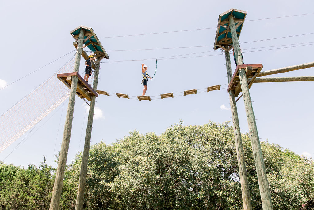 A woman walks across a platform on the Miraval Arizona Challenge Course