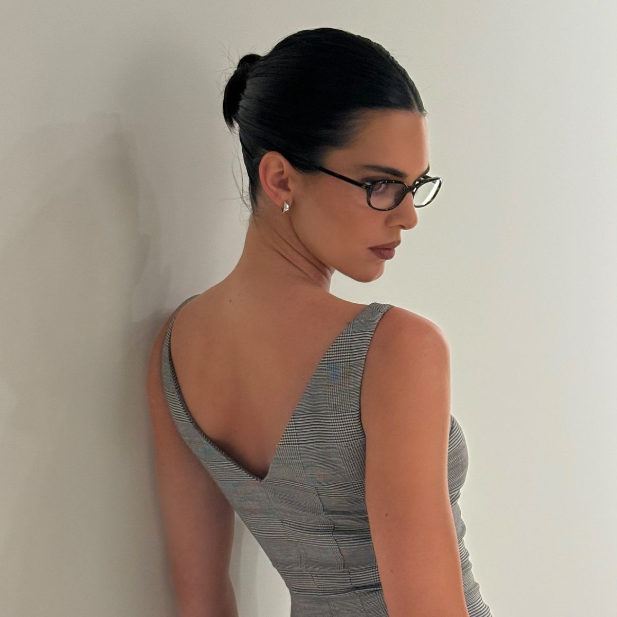 Kendall Jenner wearing glasses with a slicked back bun