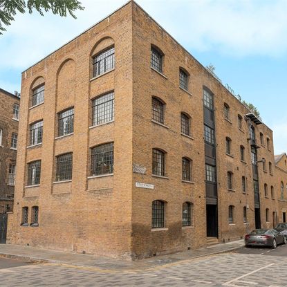 school house with brick wall and car with road