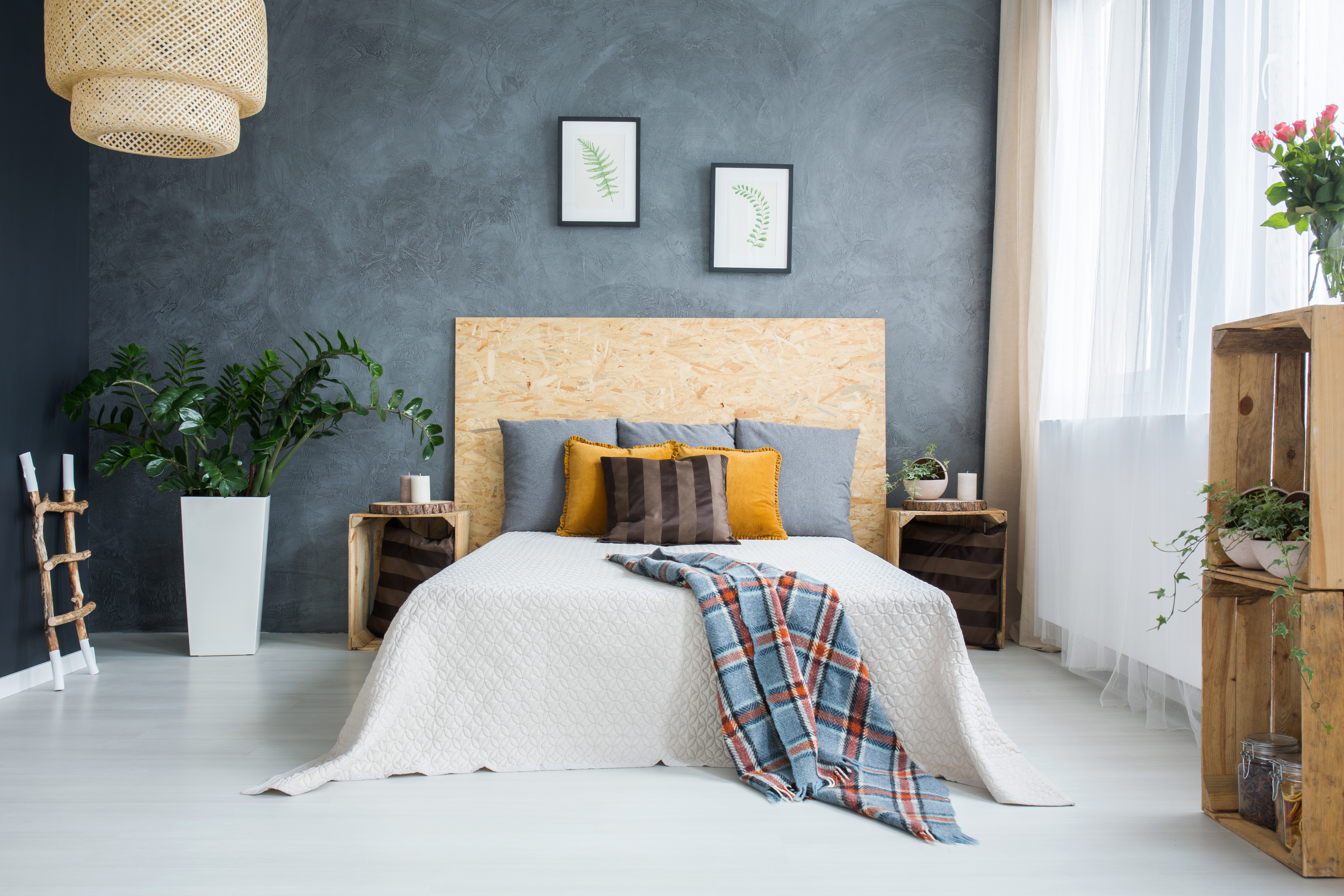 Escapism bedroom with grey walls and colourful pillows and throws