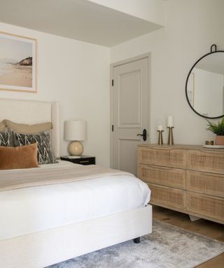 A California modern style bedroom featuring a soft upholstered headboard and a rustic wooden chest of drawers
