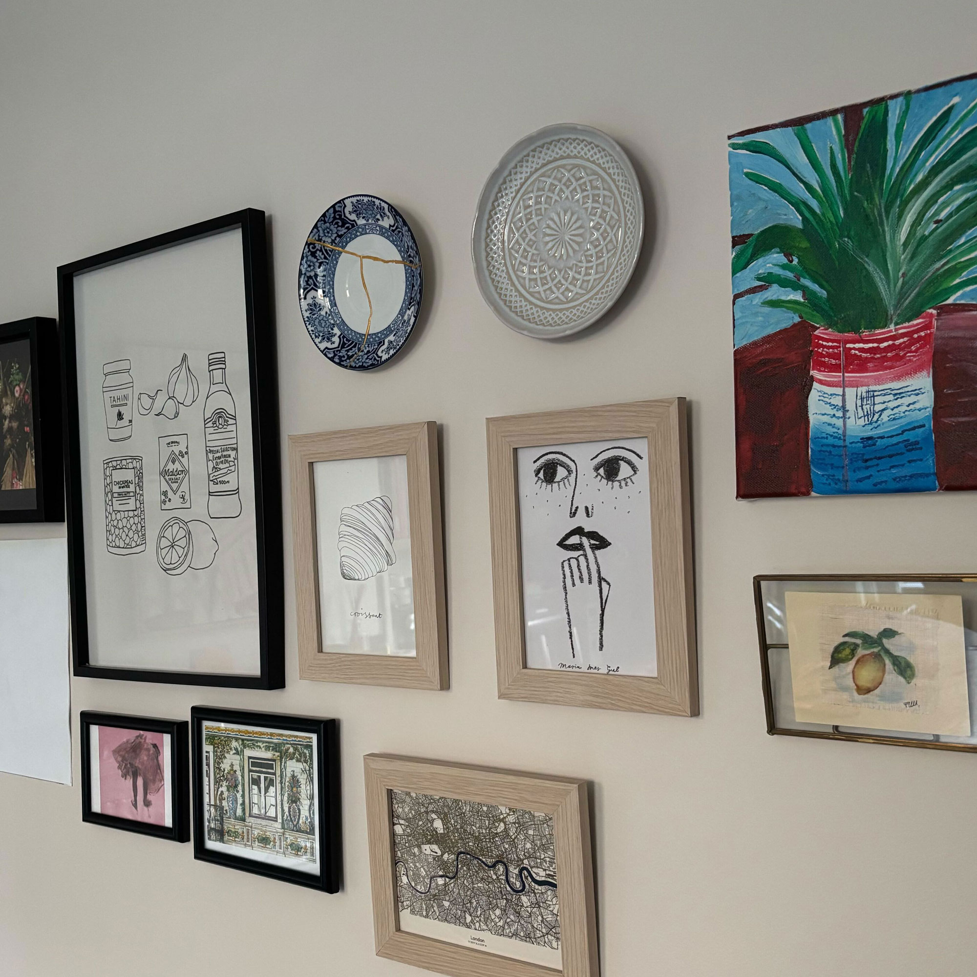 Gallery wall with plates, frames and canvas on a white wall