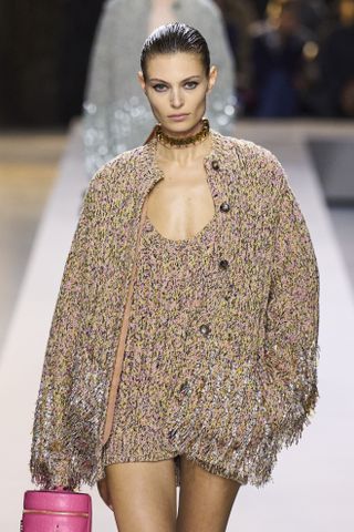 Woman in cardigan on Gucci runway.