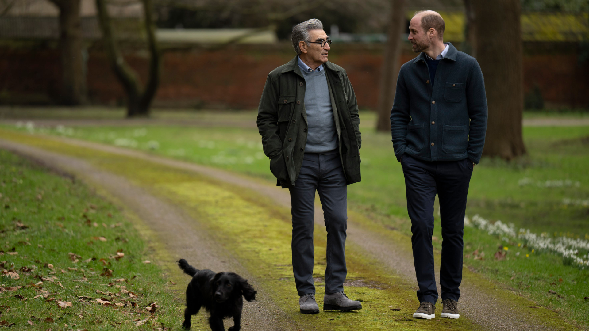 Prince William walking with Eugene Levy and Orla the dog through a park
