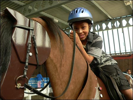 A local child tries out the mechanical horse at the interactive launch of the Equine Health and Welfare Strategy