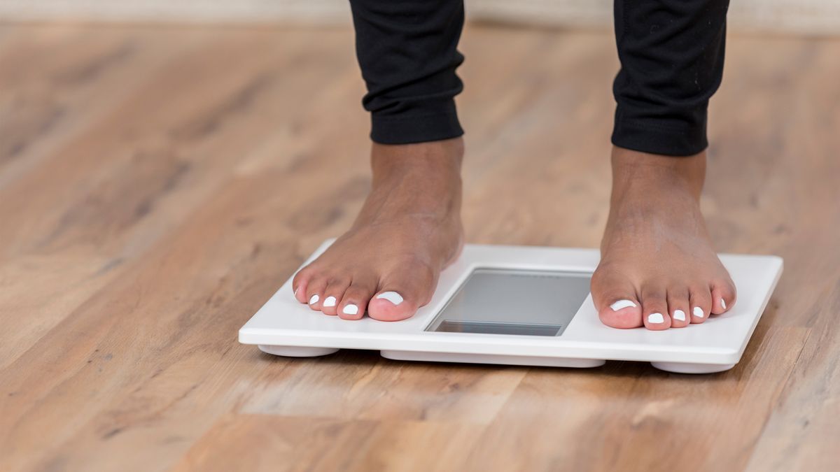 woman&#039;s feet standing on a pair of scales