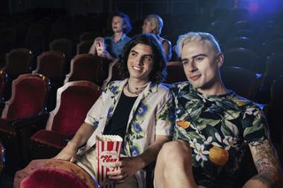 Two students are watching a film at the cinema.