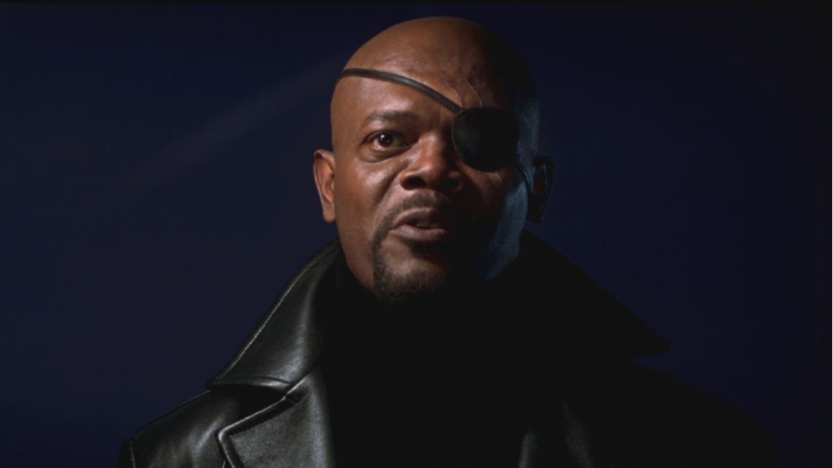 Samuel L. Jackson wears his iconic eye patch while talking in front of a window in Iron Man.