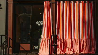 a storefront with large striped curtains