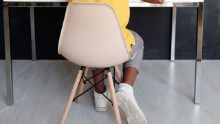 How to clean an office chair: Boy sitting in a plastic chair