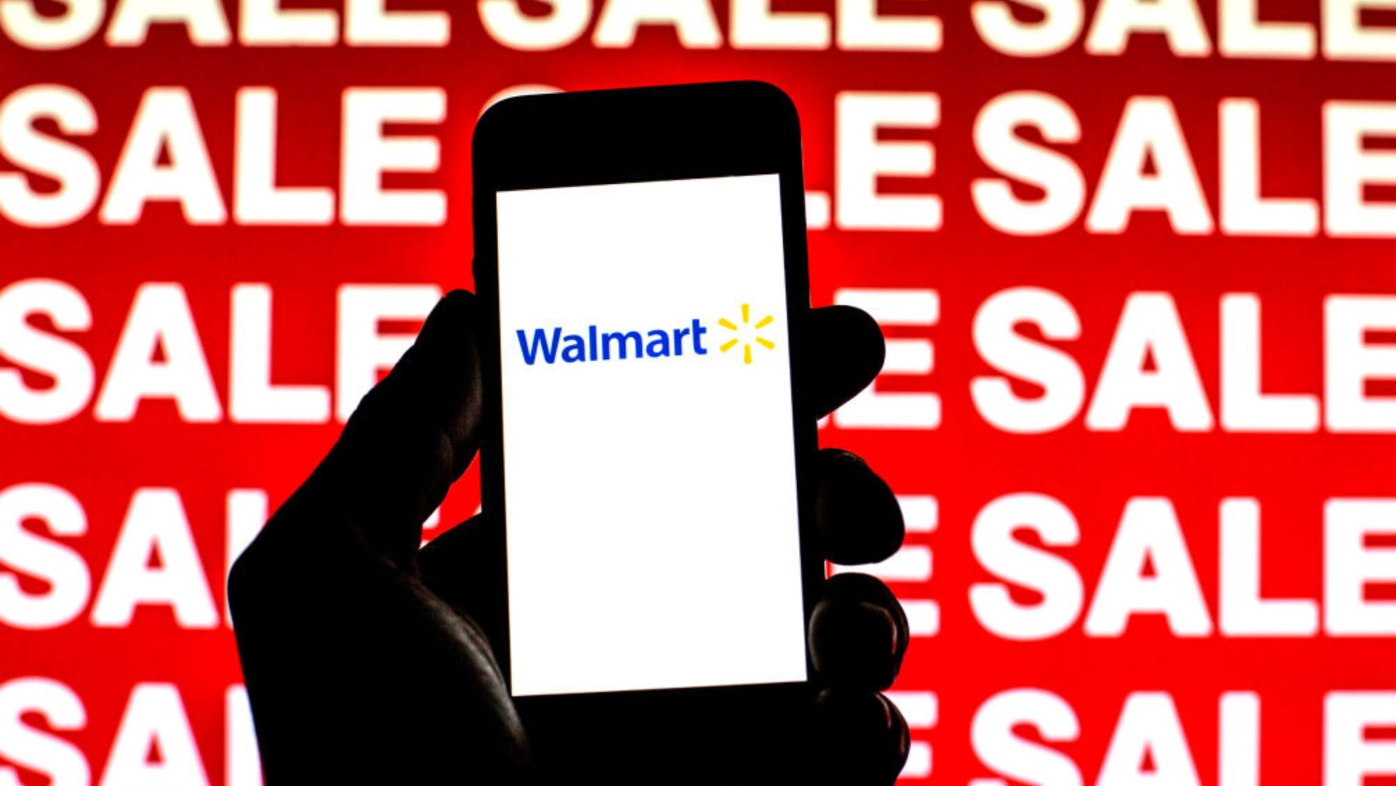 In this photo illustration, a Walmart logo is seen on a smartphone screen with 'Sale' words in the background.