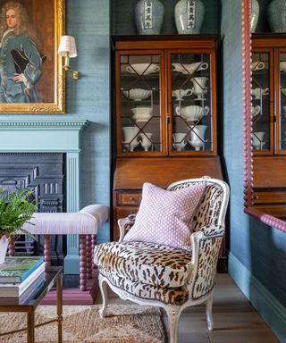 Traditional blue dining room with an antique brown cabinet filled with a ceramic urn vase collection